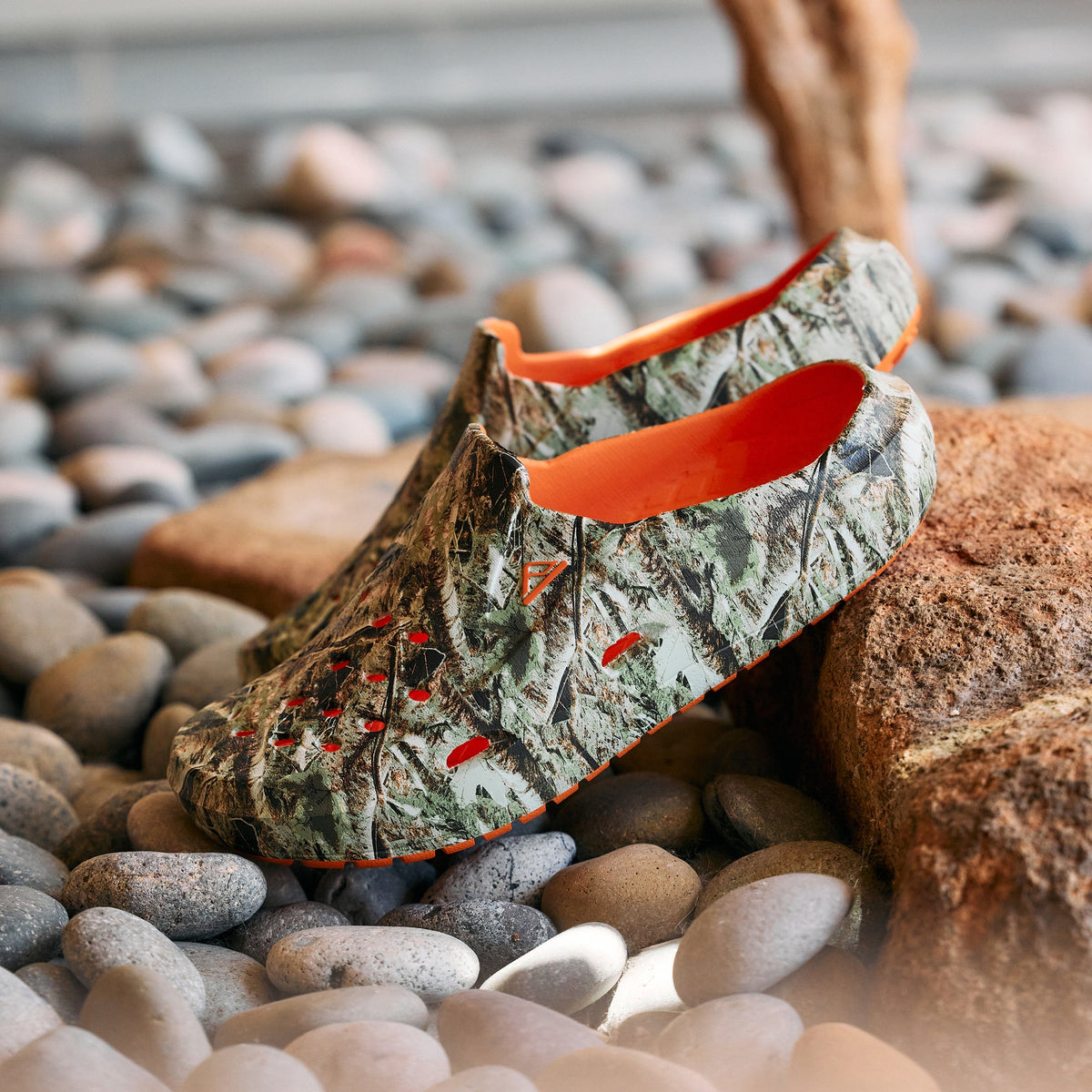 Glider water-friendly footwear facing left on beach stones, showing cushioned footbeds and molded comfort design
