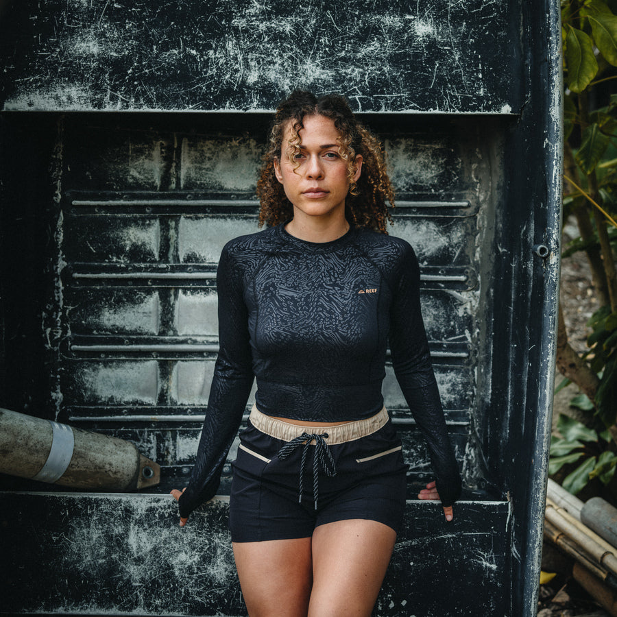 Woman wearing Robyn Short in black with beige waistband, front view, styled for an active beach lifestyle with comfort focus