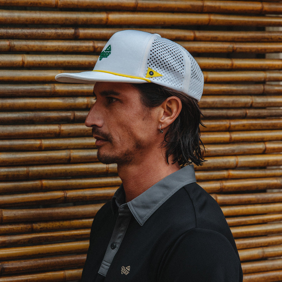 Side profile of man wearing Blackball Hat with mesh back, surf-inspired design, and lightweight comfort features