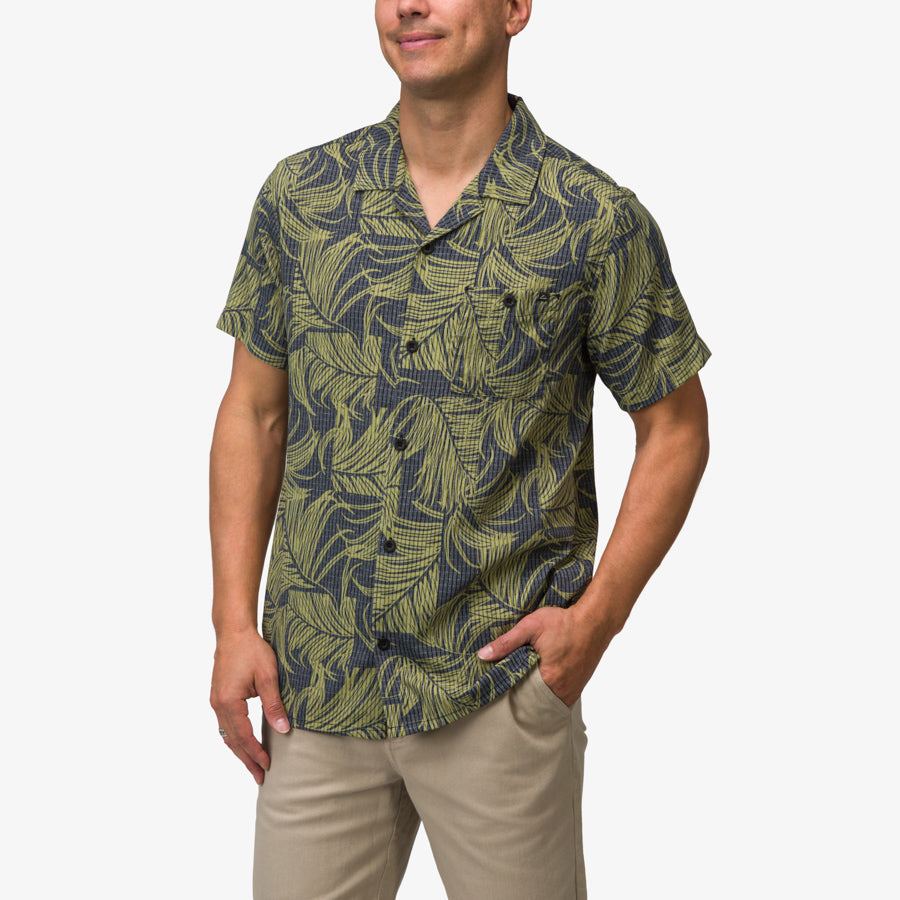 Men wearing Kantis Shirt with green and black tropical leaf pattern, front view showing relaxed fit and short sleeves.