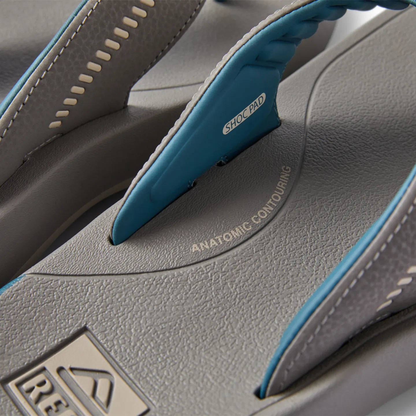 Close-up of the grey Cruiser sandal footbed facing up, showing arch support and blue shock pad strap with anatomic contouring.