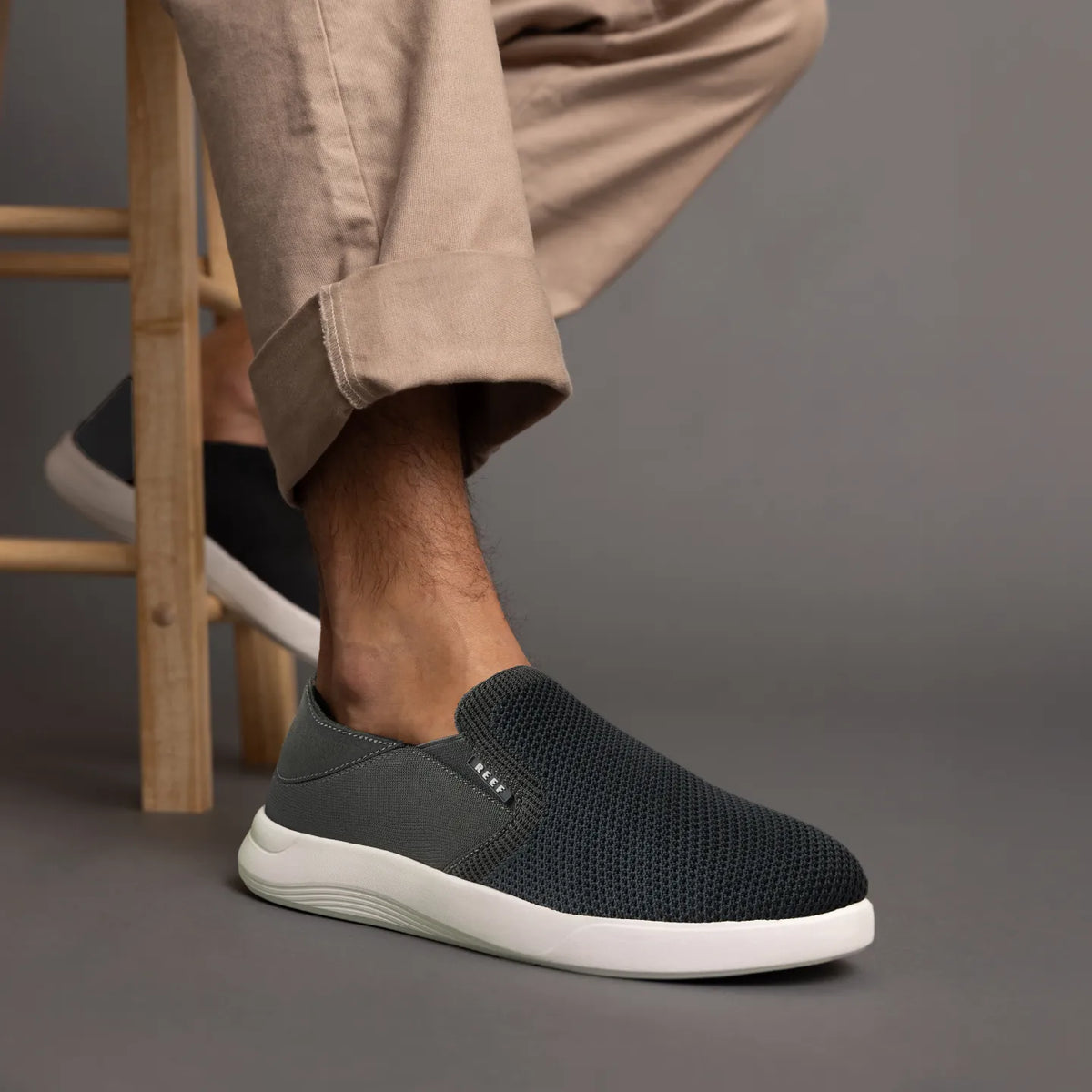 Neptune Slip-On facing right on a foot, featuring breathable mesh upper and cushioned white sole for beach comfort.