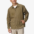 Front view of olive Landon Coat worn by a man, showcasing durable fabric, multiple pockets, and casual beach-inspired style.