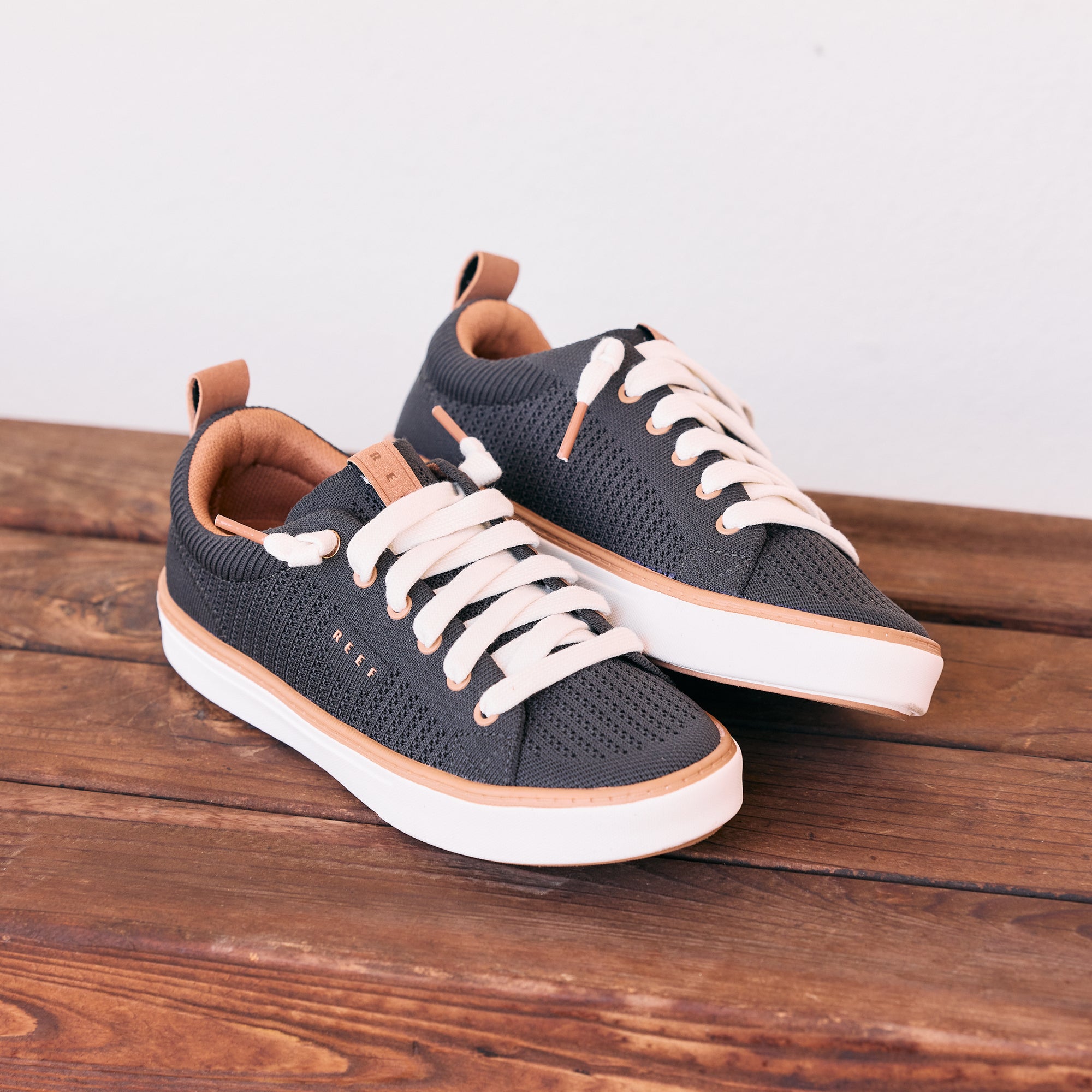 Lay Day Lite black sneakers angled with toes facing right on a wooden surface