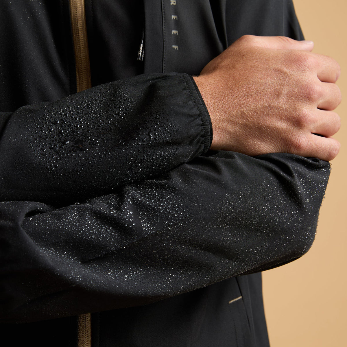 Close-up of the left sleeve of the Garvey Full Zip Jacket with water droplets, highlighting water-friendly design.