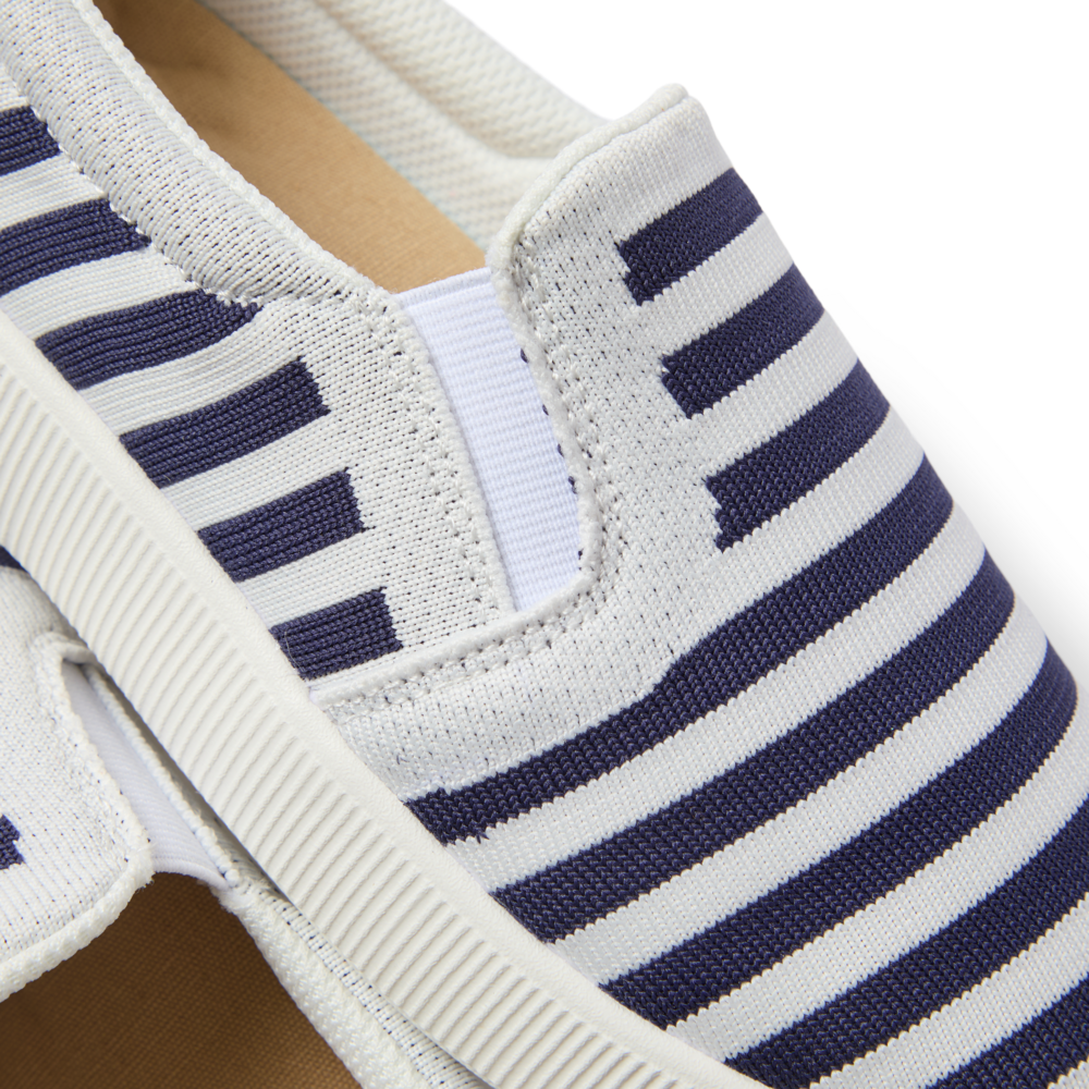 Neptune Elyse women's shoe close-up showing navy and white striped upper, lightweight sole, and elastic side detail facing left.