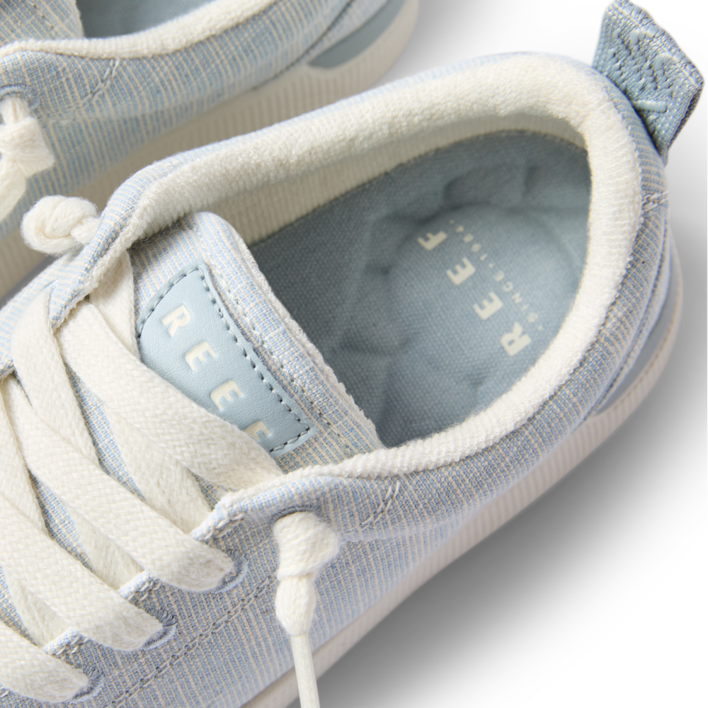 Close-up top view of the Neptune Alana sneaker laced and facing forward with cushioned collar in light blue textile.