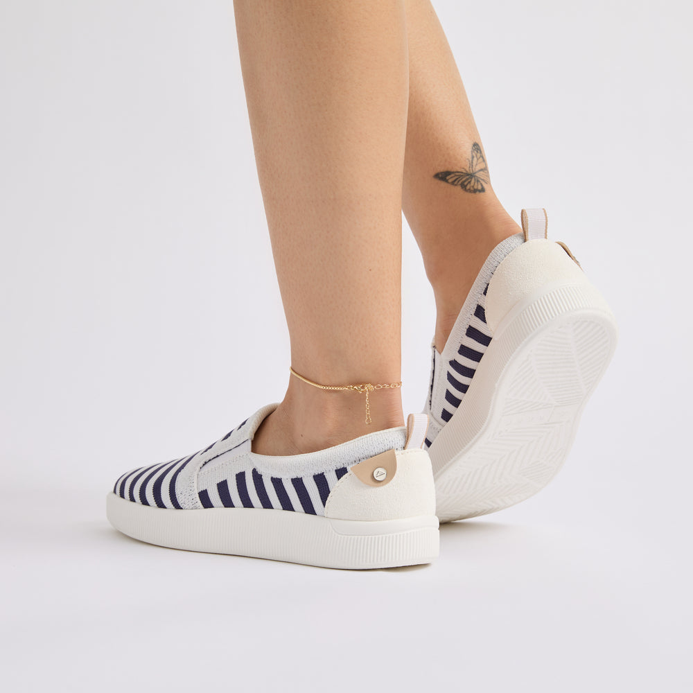 Neptune Elyse women's navy and white striped slip-on shoes facing back right, showing cushioned heel and sole for comfort.