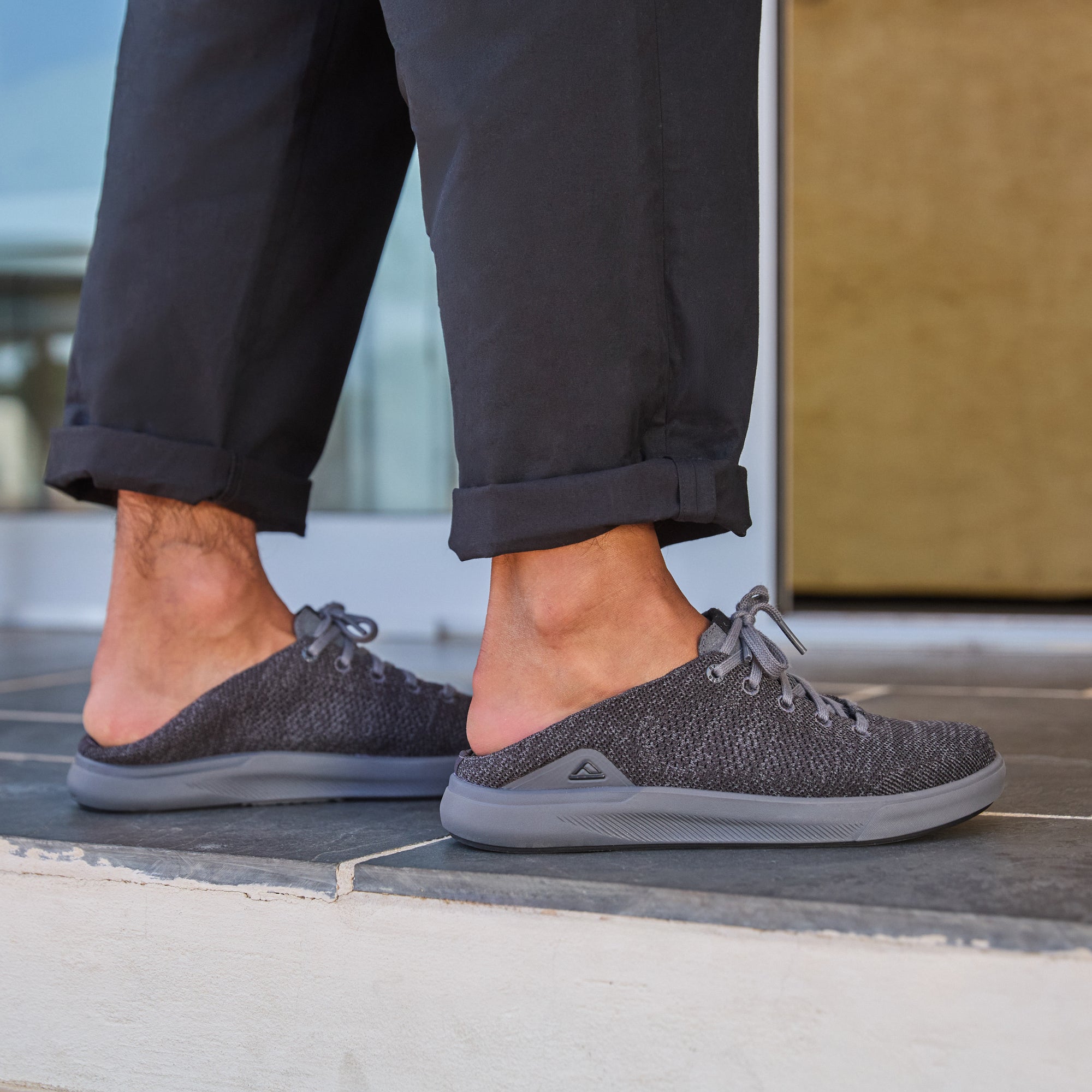 Neptune HT men's black sneaker mule facing right with breathable knit upper, REEFlex cushioning, and anatomical arch support.