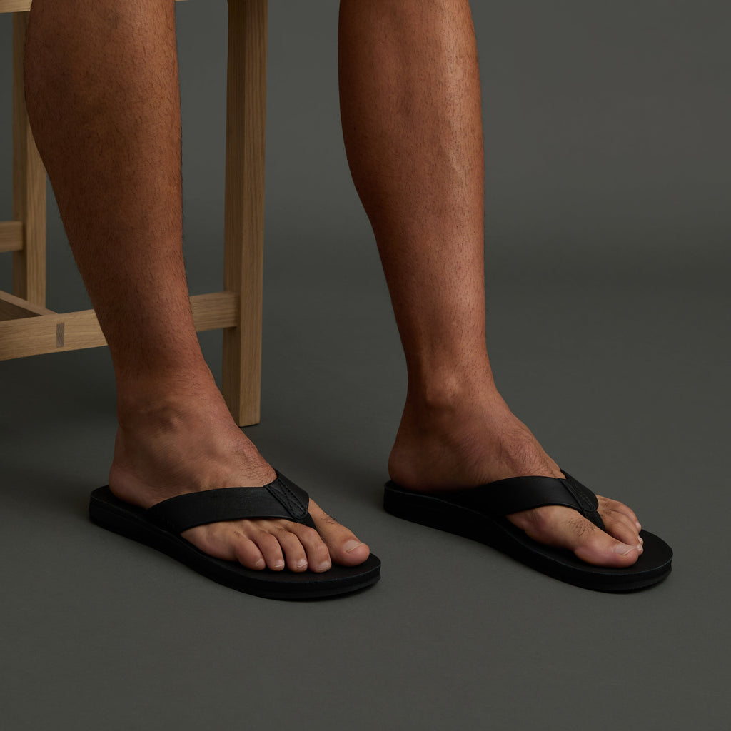 Ojai Classic black men's sandals facing forward worn on feet, showing toe and arch support for beach comfort.