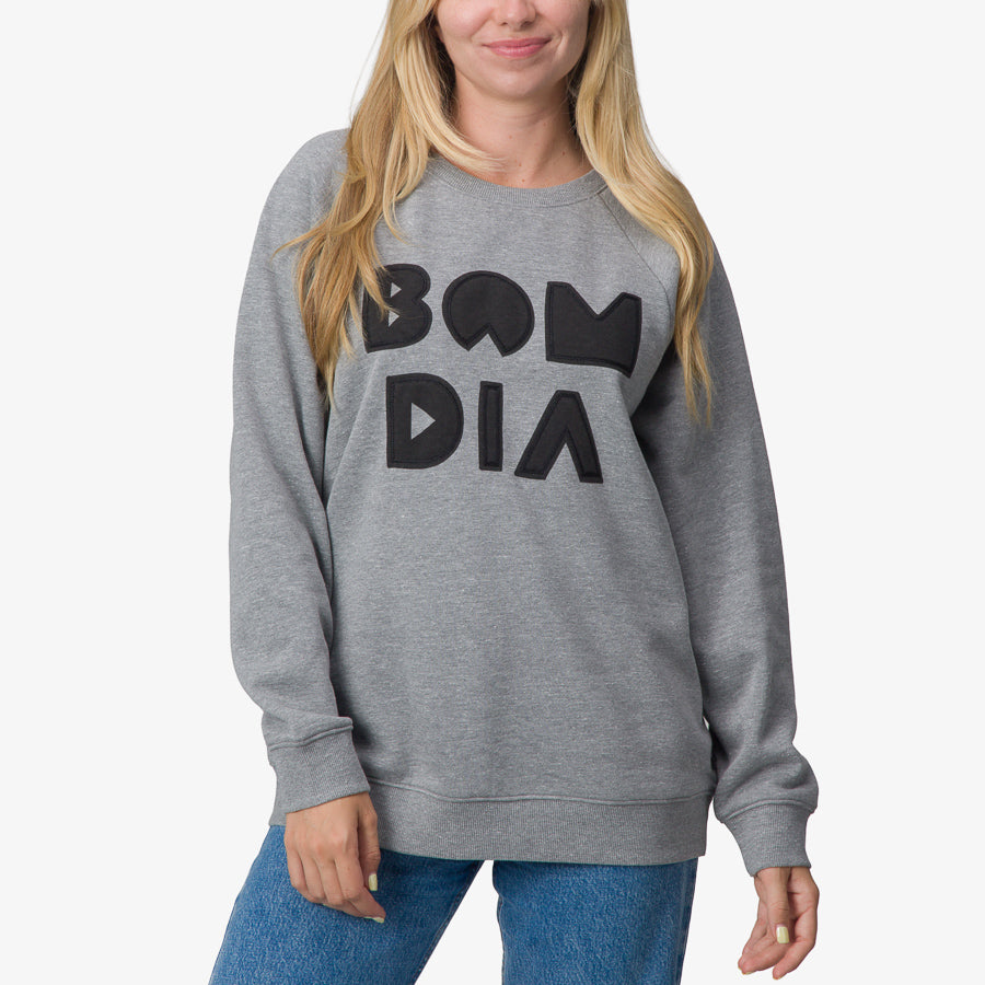 Woman wearing grey Oversized Raglan Fleece with black graphic text, front view, highlighting comfort and casual style.