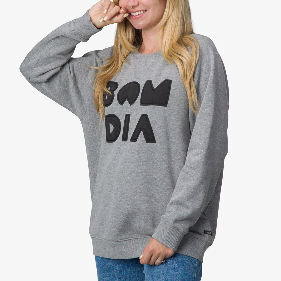 Woman wearing gray Oversized Raglan Fleece with black print, front view showing relaxed fit and long sleeves