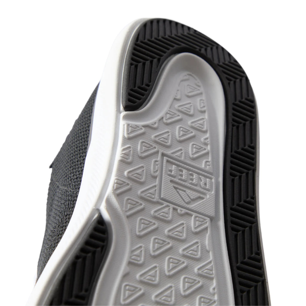 Close-up of the black Neptune HT shoe sole facing upward, showing durable, water-friendly tread with REEF comfort technology.