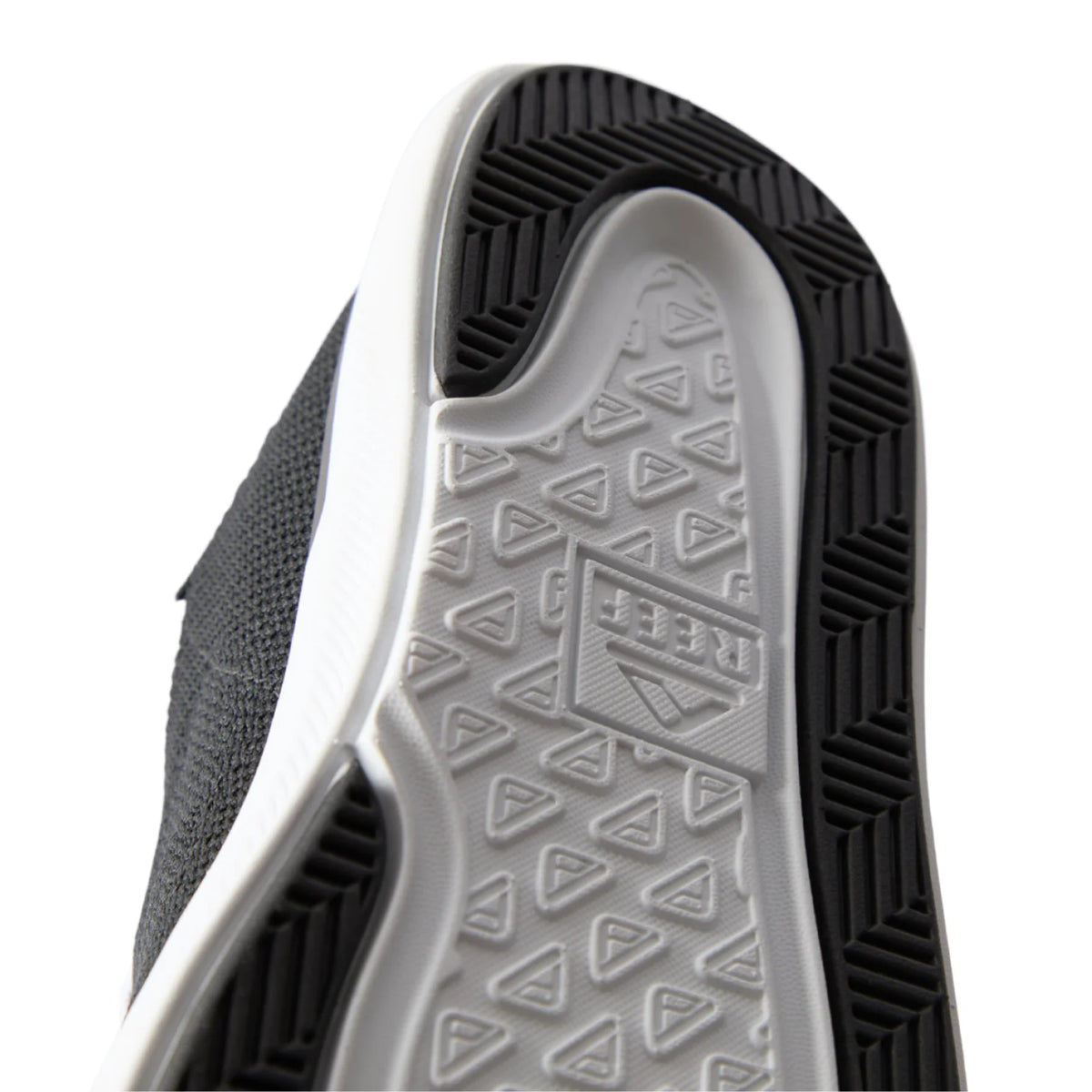 Close-up of the black Neptune HT shoe sole facing upward, showing durable, water-friendly tread with REEF comfort technology.
