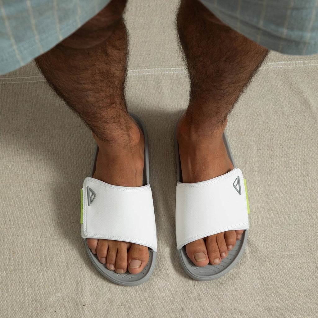 Top-down view of feet wearing white Phantom Slab slides facing forward, showing soft cushioning and arch support.