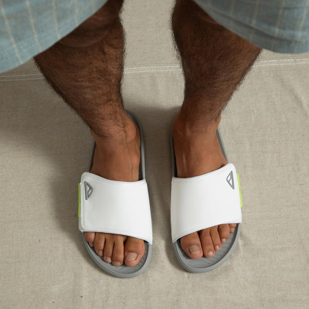 Top-down view of feet wearing white Phantom Slab slides facing forward, showing soft cushioning and arch support.