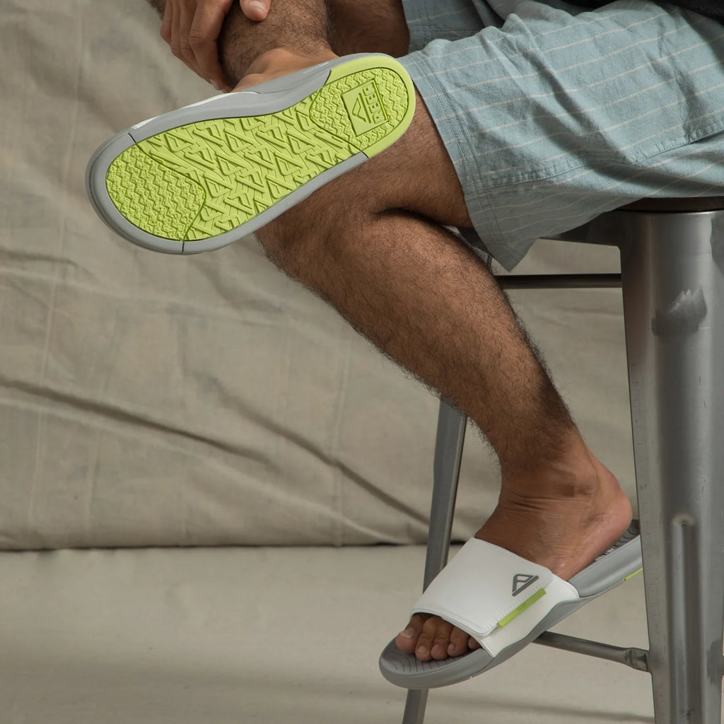 Phantom Slab slide facing left on foot, close-up of lime green rubber outsole showing grip and arch support.