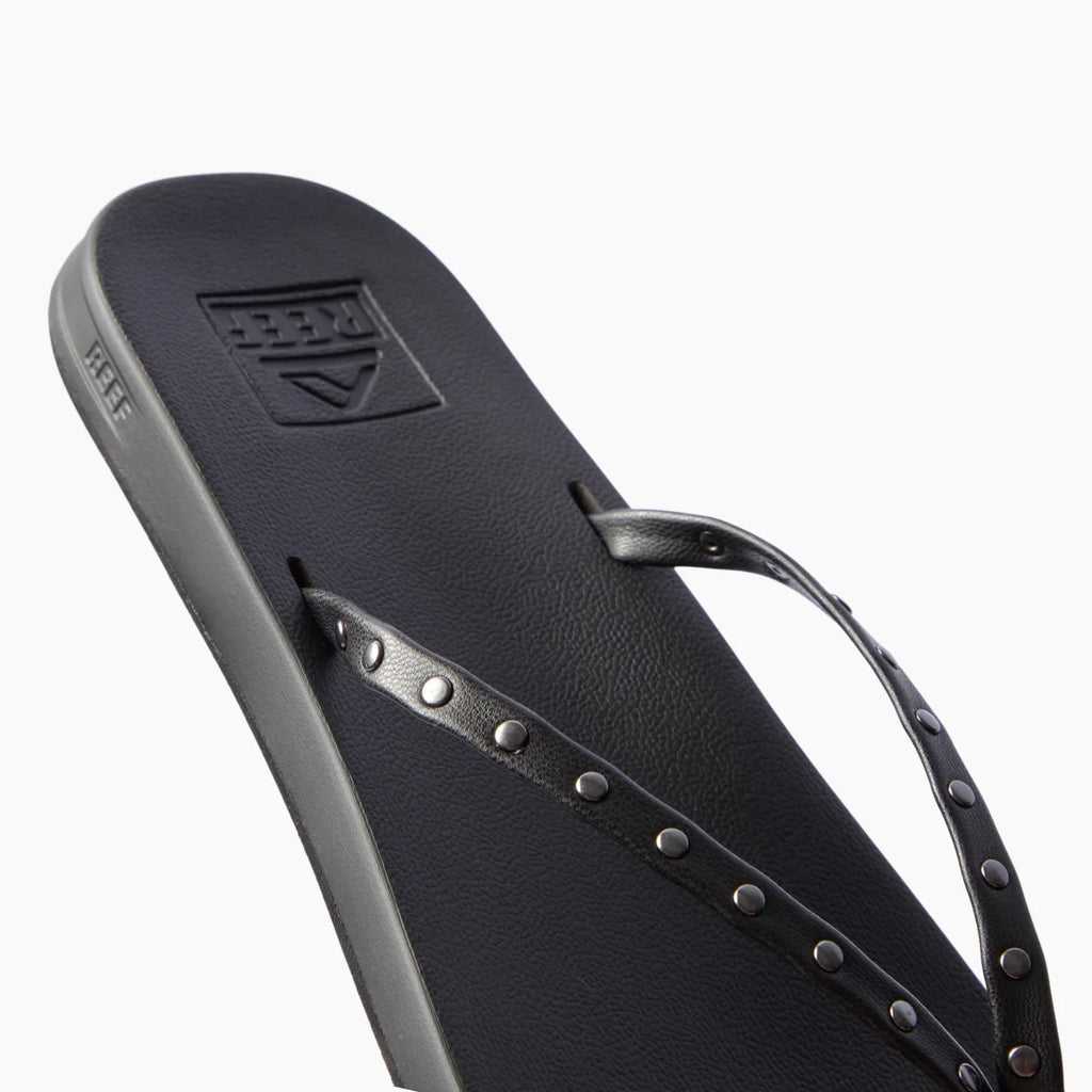 Cushion Slim Studs black women's sandal facing left, close-up of straps with slim studs, comfort-focused beach footwear.