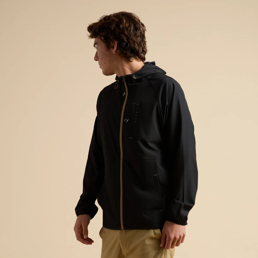Man wearing a black Garvey Full Zip Jacket facing left, showing front and side with hood and zipper detail.
