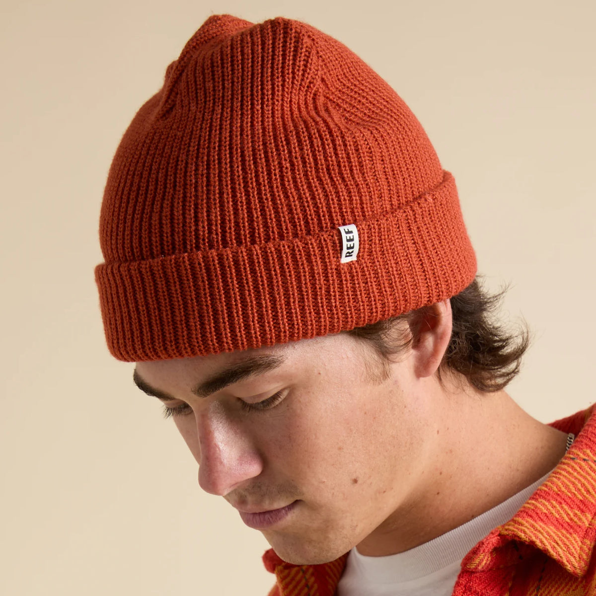 Unisex Alyx Beanie in chili red, close-up side view of surf-inspired knit hat with REEF tag, comfort-focused design.