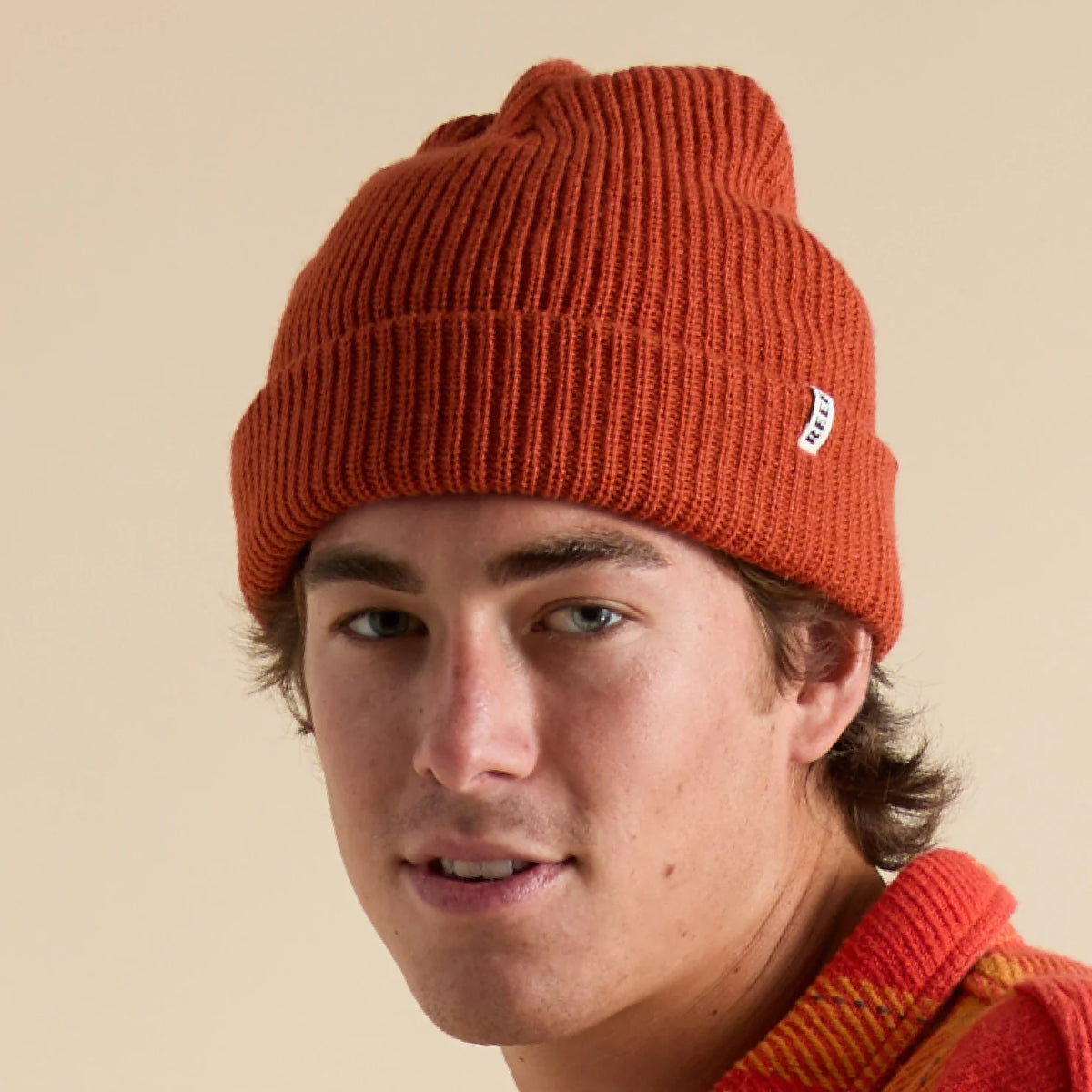 Close-up of a man wearing a chili red Alyx Beanie with a folded cuff, surf-inspired and unisex design.