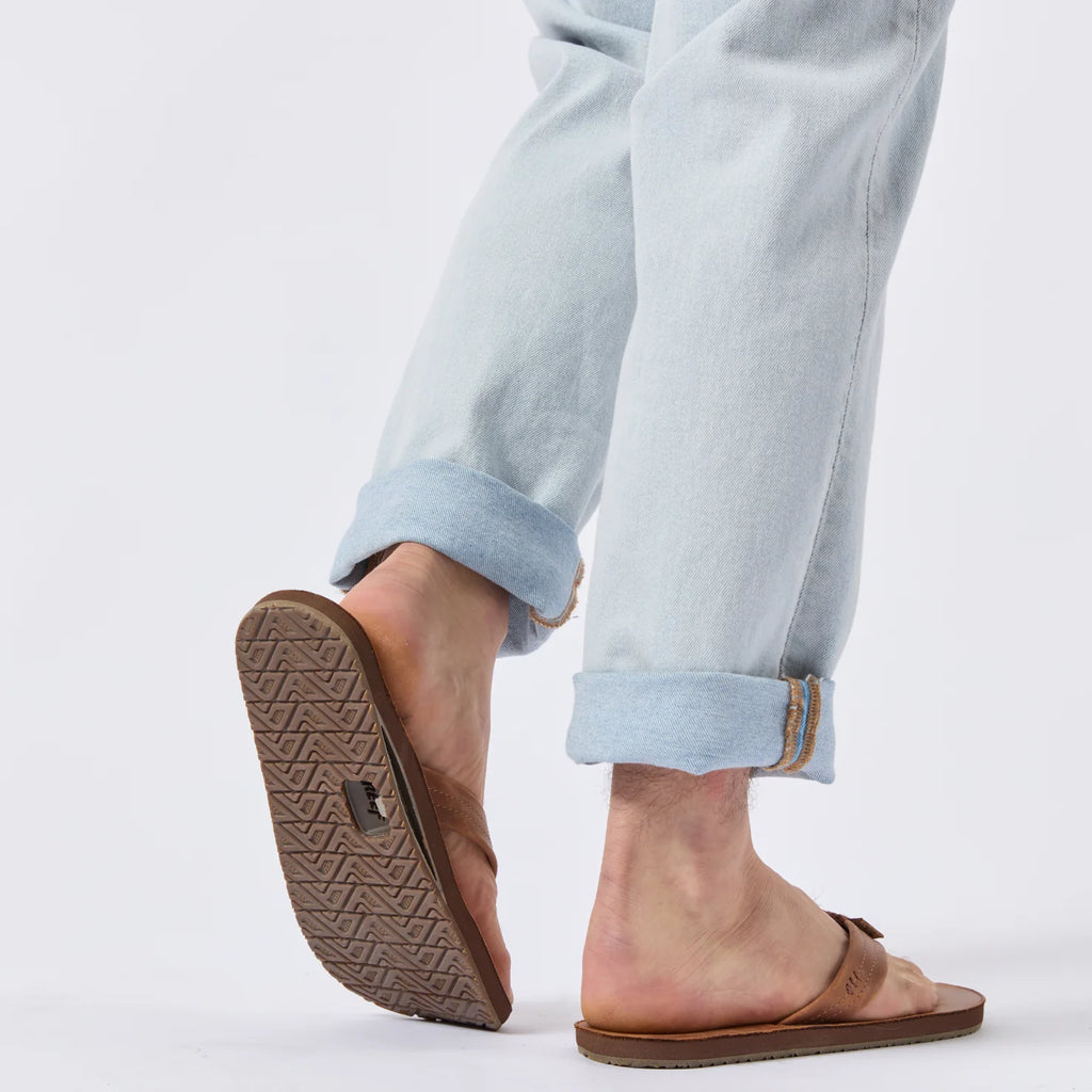Reef Draftsmen sandals on a man’s feet, showing the sole facing backward with arch support and cushioned footbed.