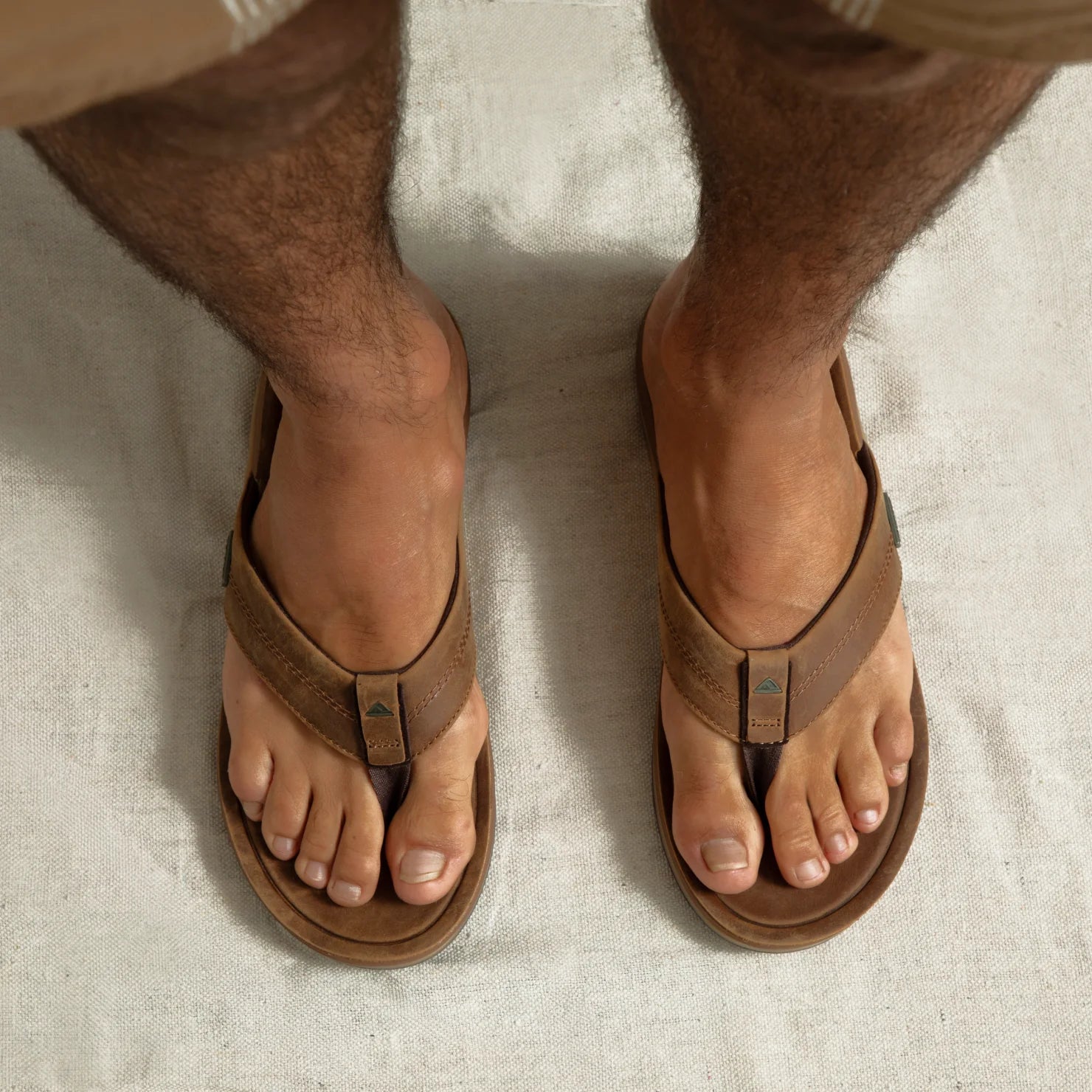 Top-down view of men's Leather Offshore sandals facing forward, showing leather straps and cushioned footbeds for beach comfort.