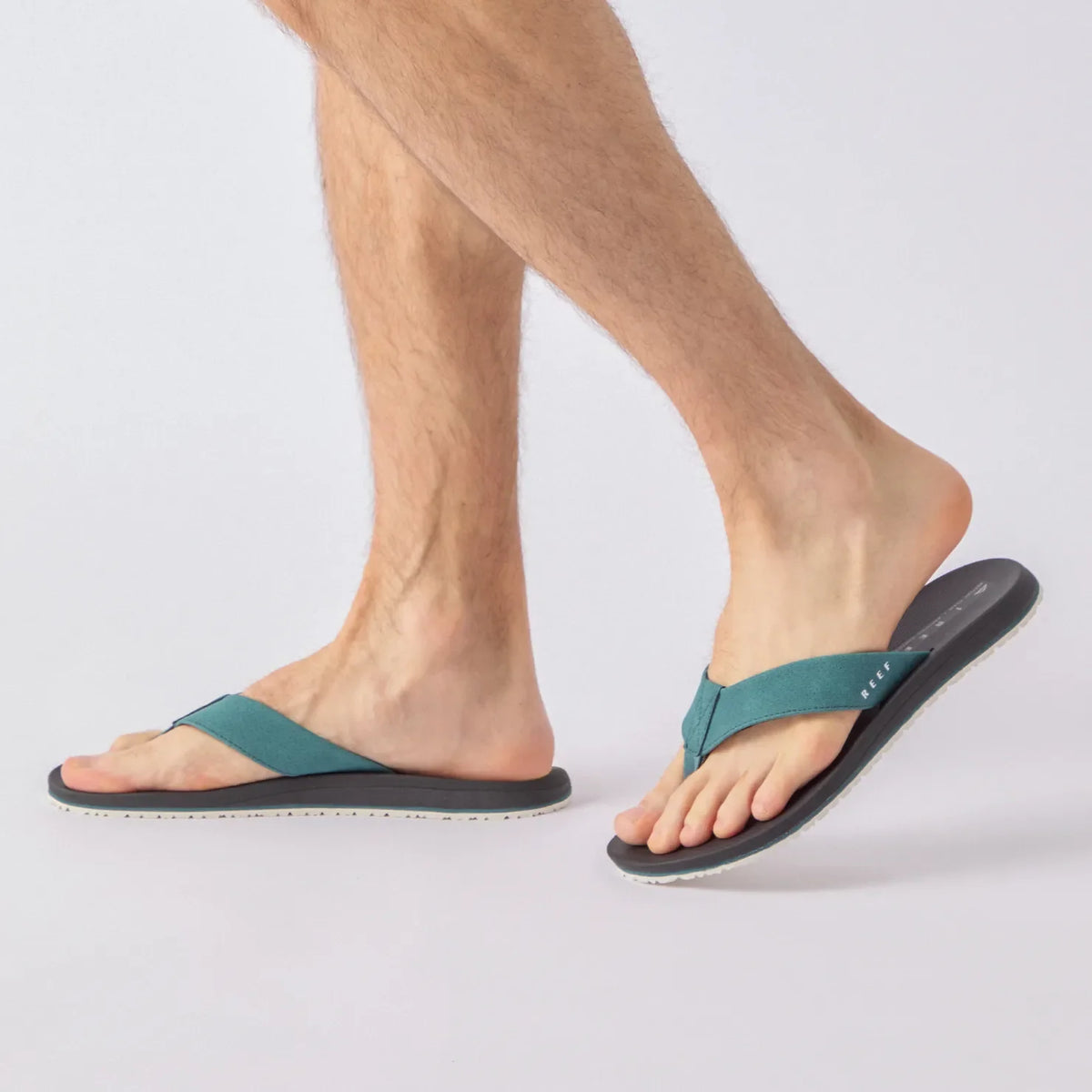 Nox men's teal and black flip flops facing left, side view, showcasing soft-rebound cushioning and anatomical arch support.