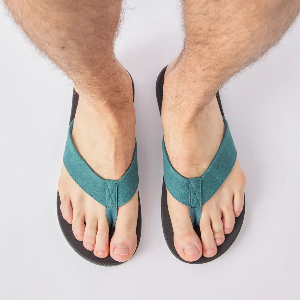 Top view of Nox men's black sandals with teal straps, showing front footbed and toe area, designed for beach comfort.