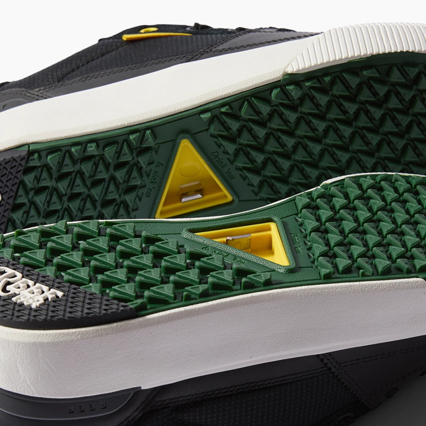 Onshore Pines men’s shoe soles facing up, showing textured green and black rubber with yellow accents for grip and comfort.