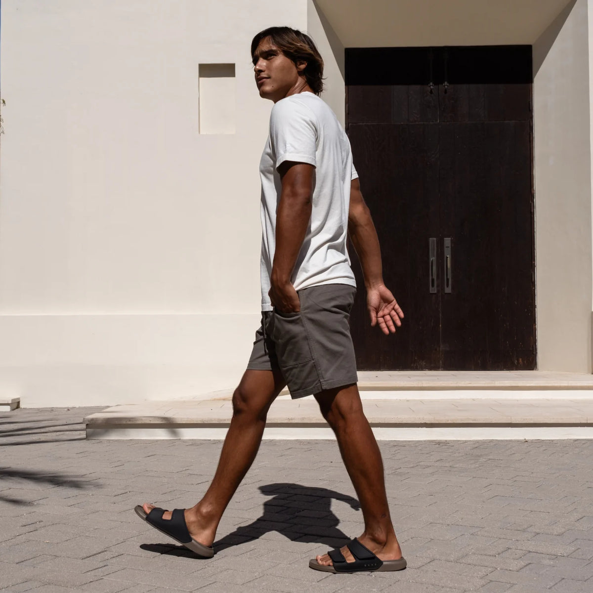 Man walking right wearing Oasis Adapt sandals facing right, showing side view with comfort and arch support design