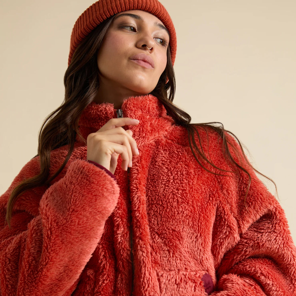 Close-up of a woman wearing a coral Pilot Sherpa Jacket front zip, showing the plush textured fabric and cozy collar.