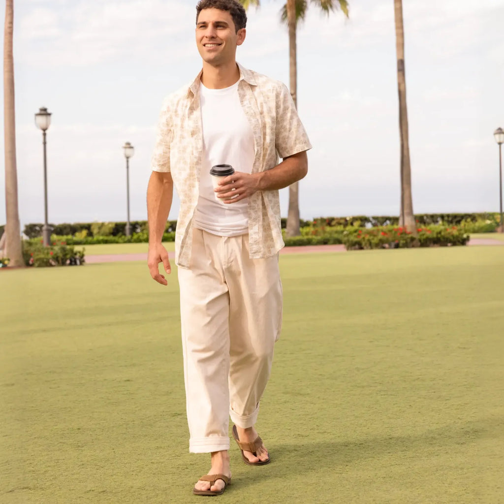 Man walking outdoors wearing Phantom Lux sandals facing forward, showcasing comfort and beach-inspired design.