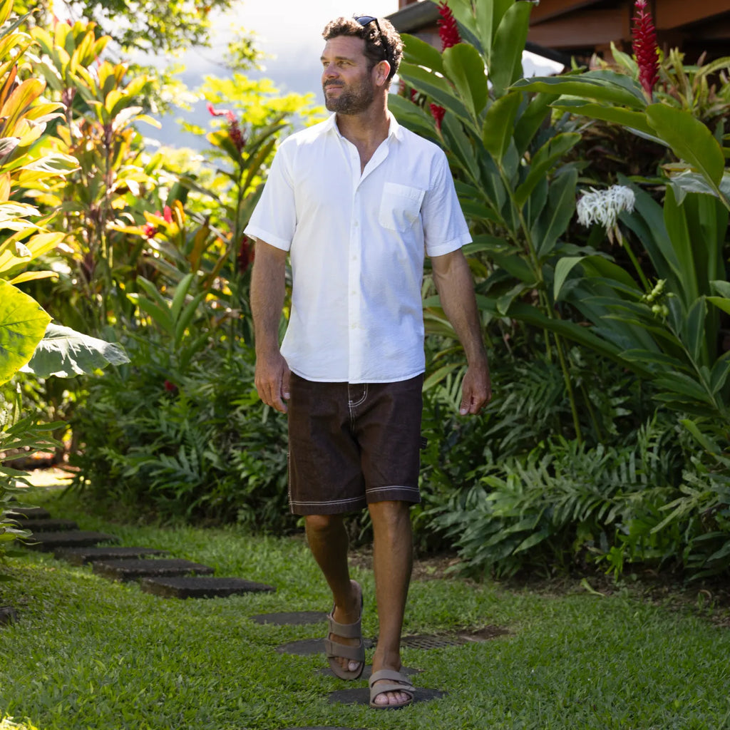 Man walking outdoors wearing Phantom Tradewind sandals facing forward, showcasing water-friendly, cushioned, tan footwear.