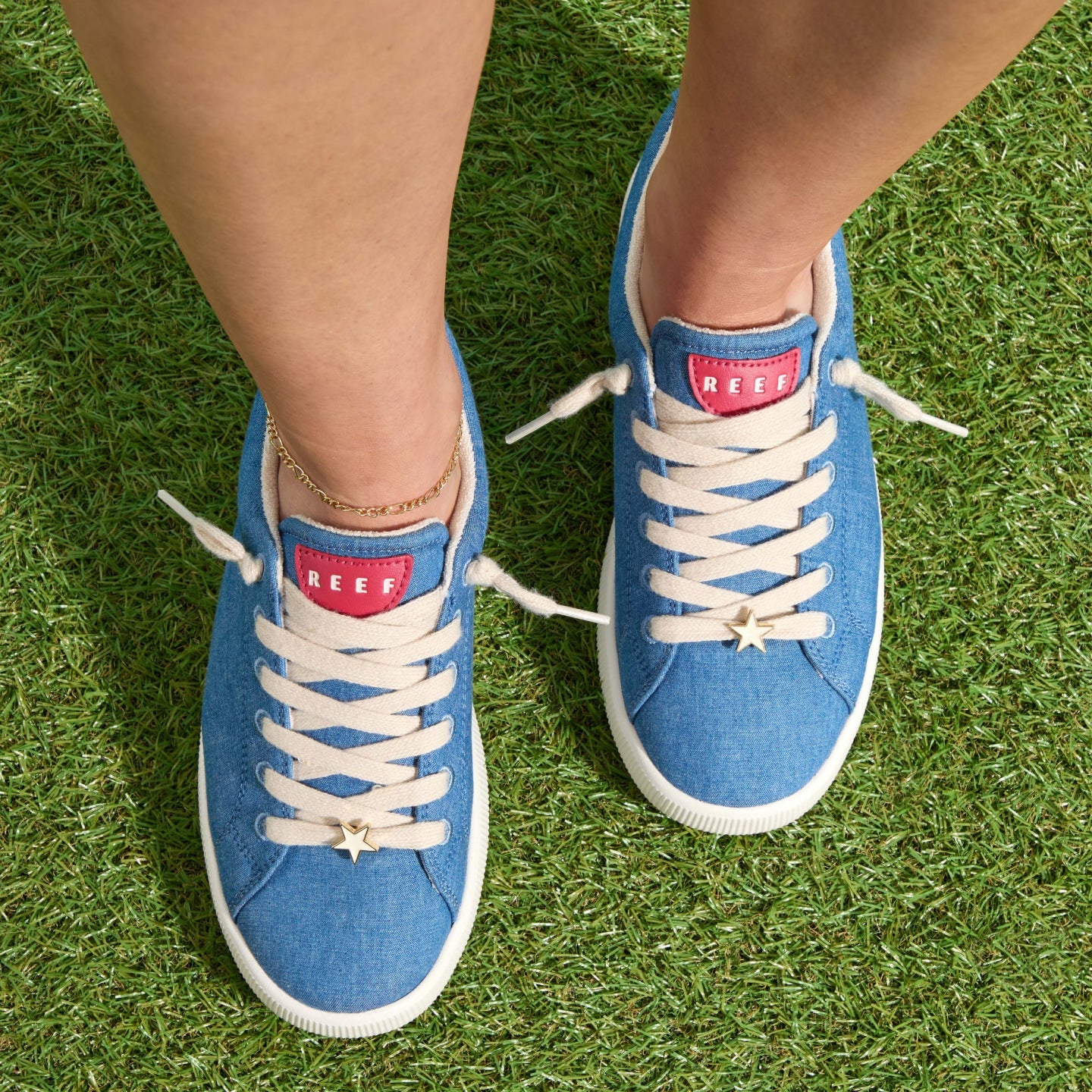 Top-down view of cheerful woman wearing blue Neptune Alana sneakers facing forward, showcasing cushioned, arch-support design.