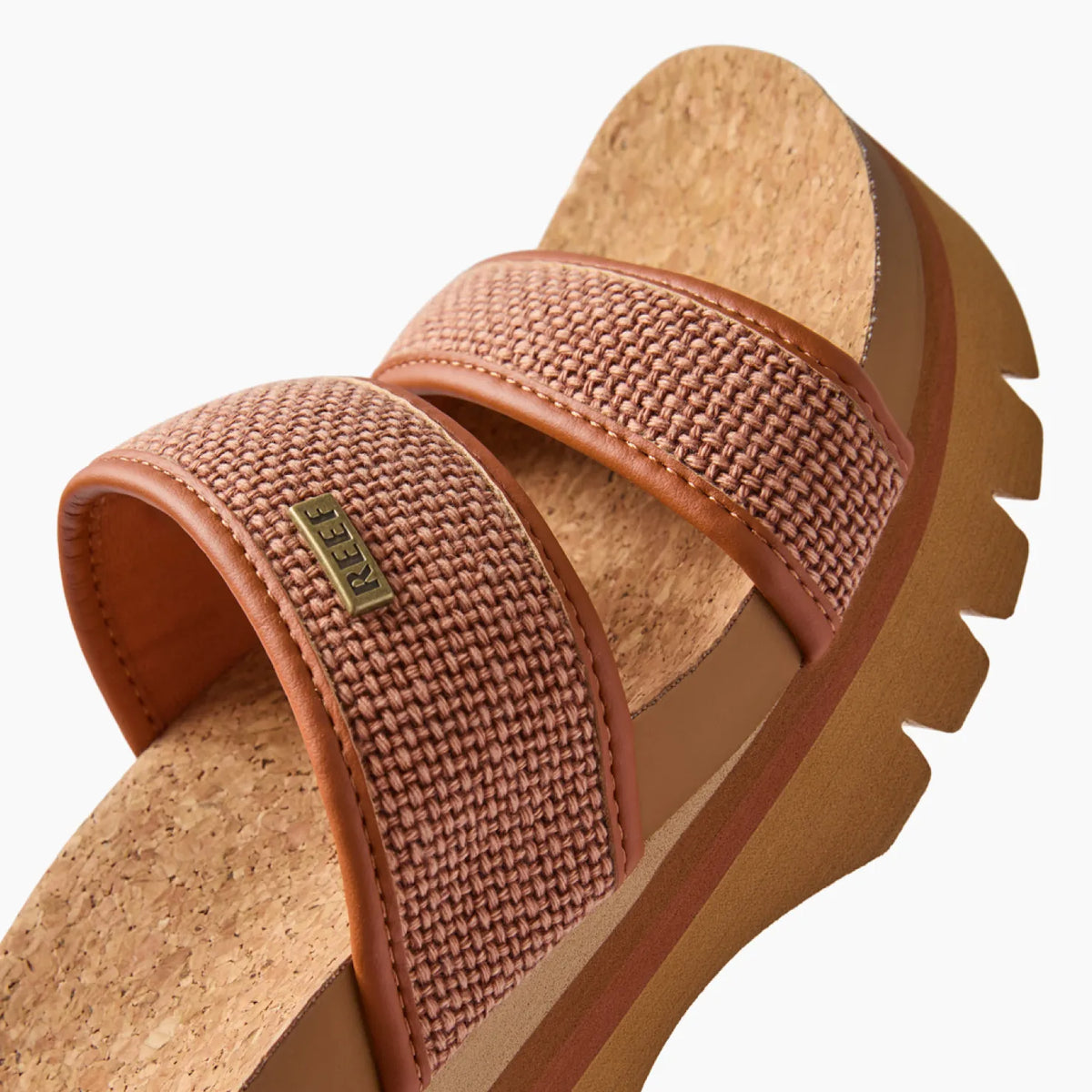 Close-up of Cushion Vista Higher sandal facing left with woven amber straps and cork footbed, surf-inspired comfort design