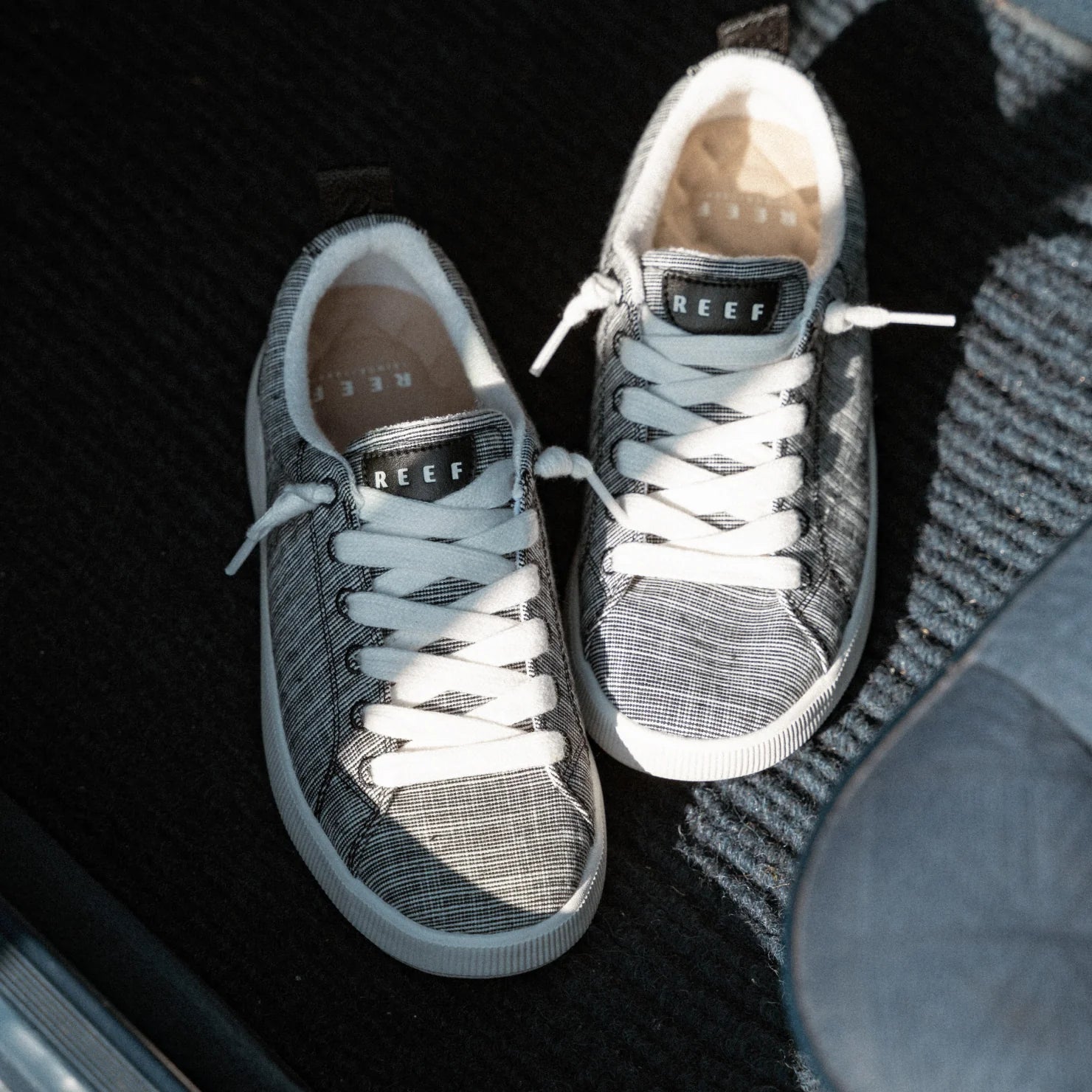 Neptune Alana women’s sneakers facing up, black and white with REEF logo, breathable, lightweight for everyday beach comfort.
