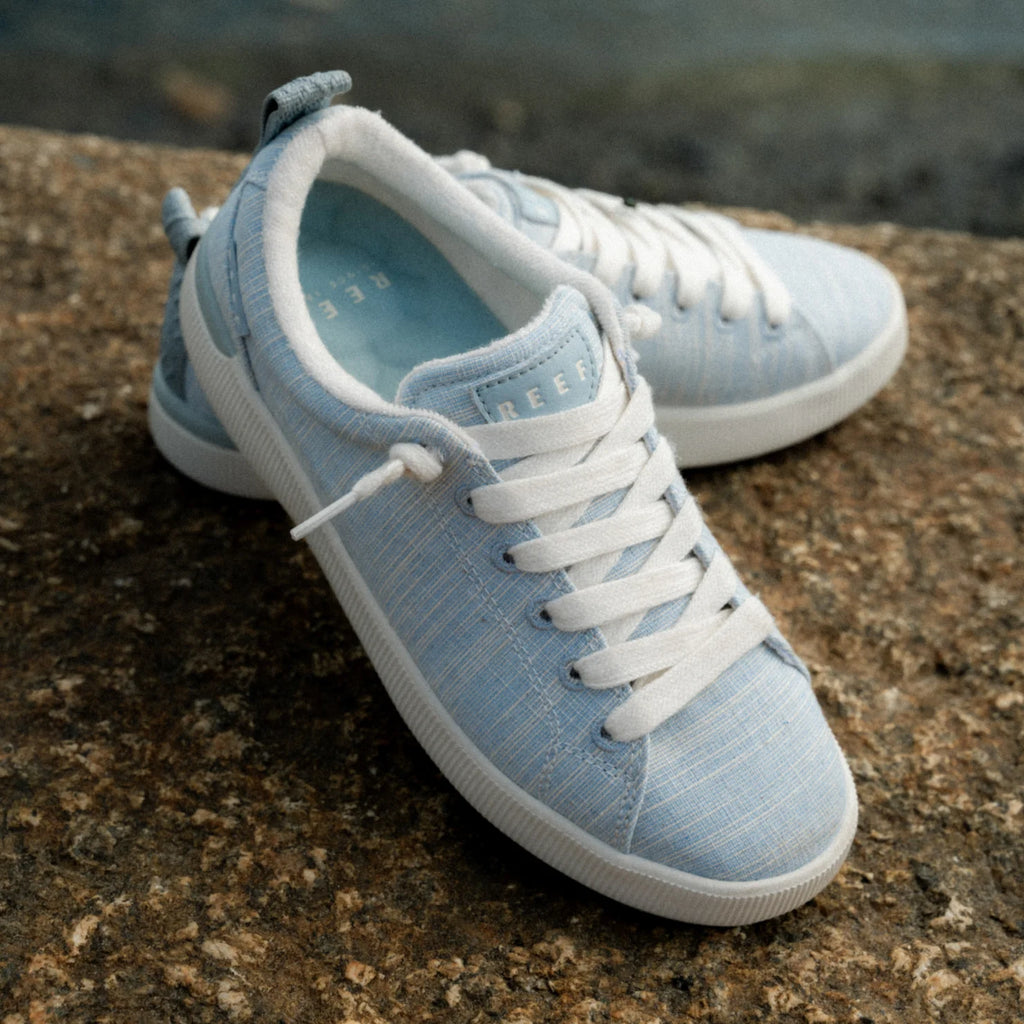 Pair of Neptune Alana women's sneakers in light blue facing right, showing top and side for casual, beach-inspired comfort.
