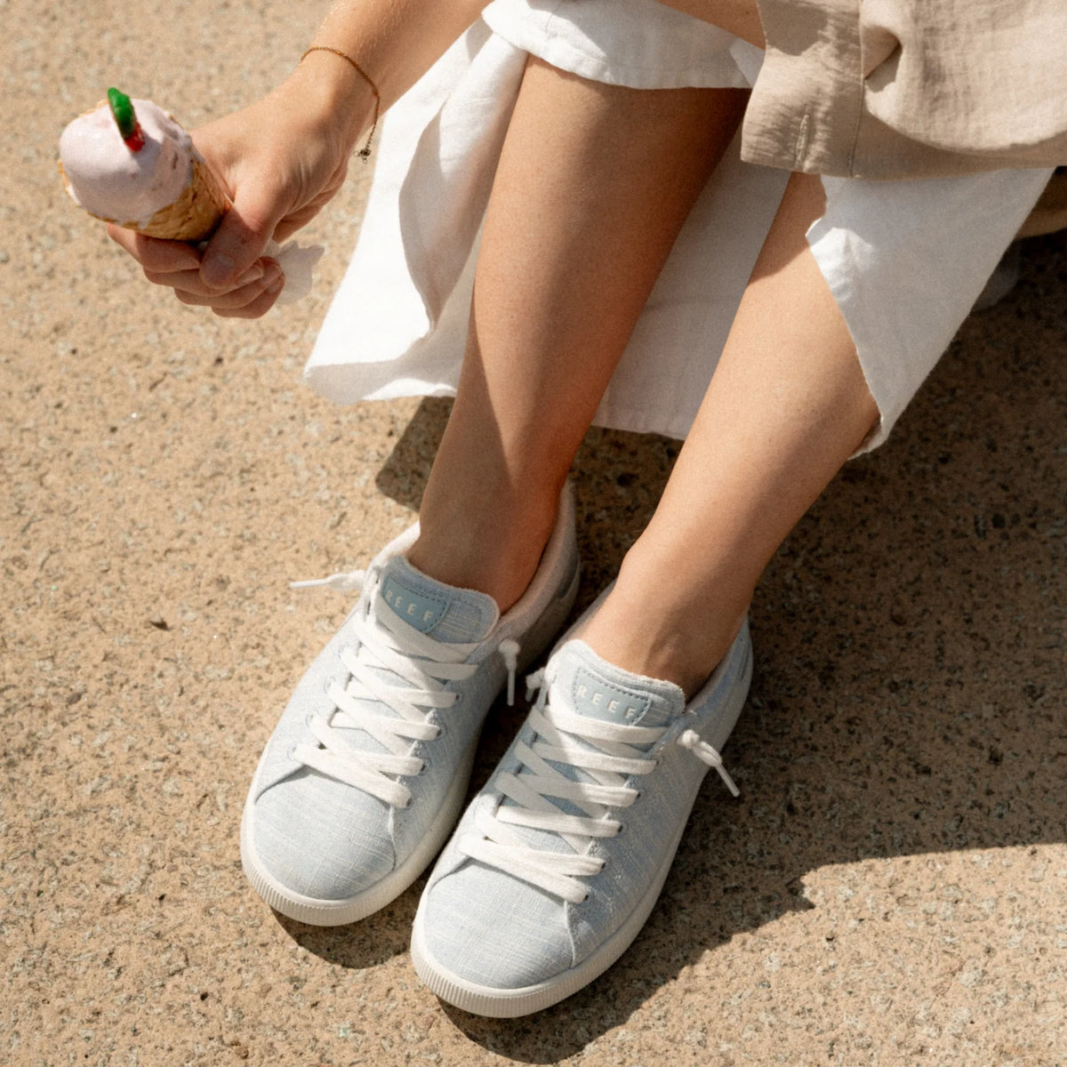 Close-up of feet wearing Neptune Alana sneakers facing forward in soft blue with extra cushion and arch support, beach-inspired comfort.