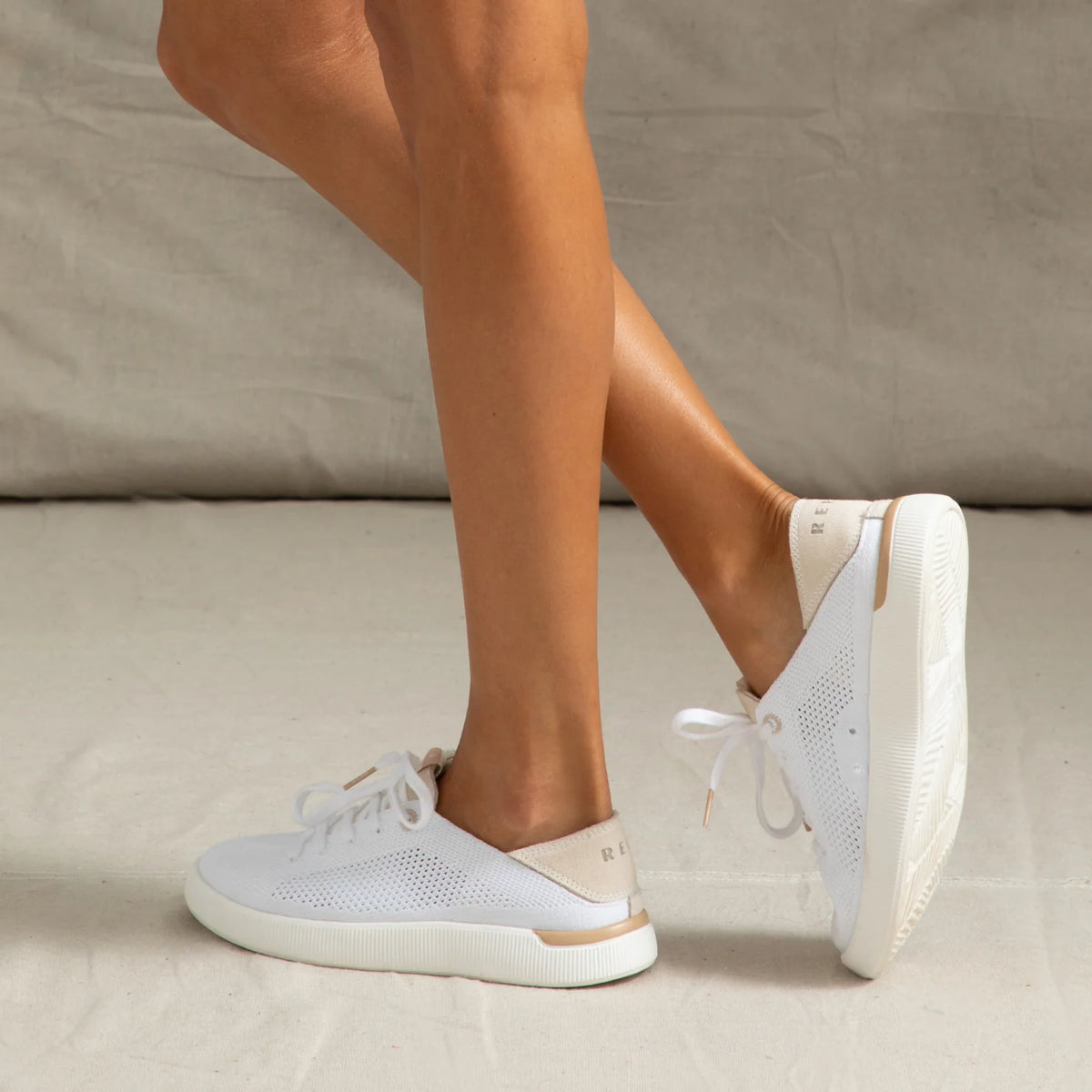 Reef Neptune shoes facing right, breathable white knit upper with cushioned sole and lightweight flexible design.