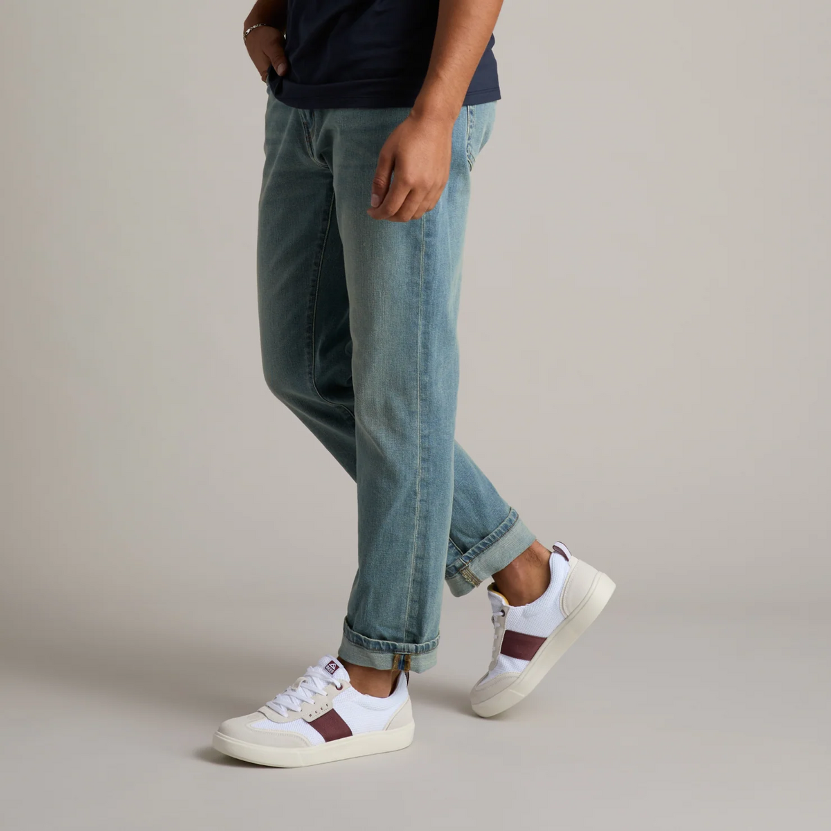 Triton shoes in white with burgundy stripe, right foot forward, showing side and top view, lightweight and comfortable design.