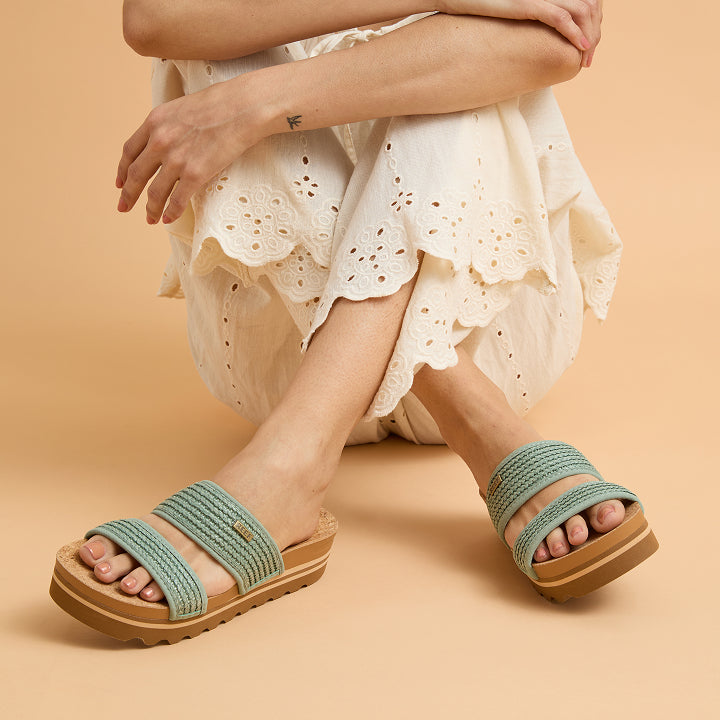 Front-facing Cushion Vista Hi sandals on feet with extra cushioning and arch support in a casual seated pose