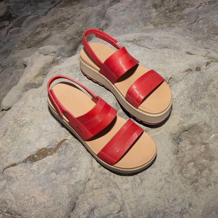 Pair of red Water Vista Higher sandals for women facing upward, showing straps and cushioned footbed on rock surface.