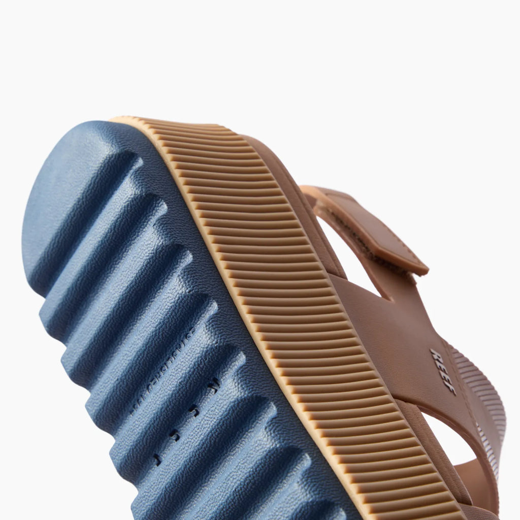 Water Vista Higher sandal close-up of sole showing navy textured grip and tan platform in rippled design facing left