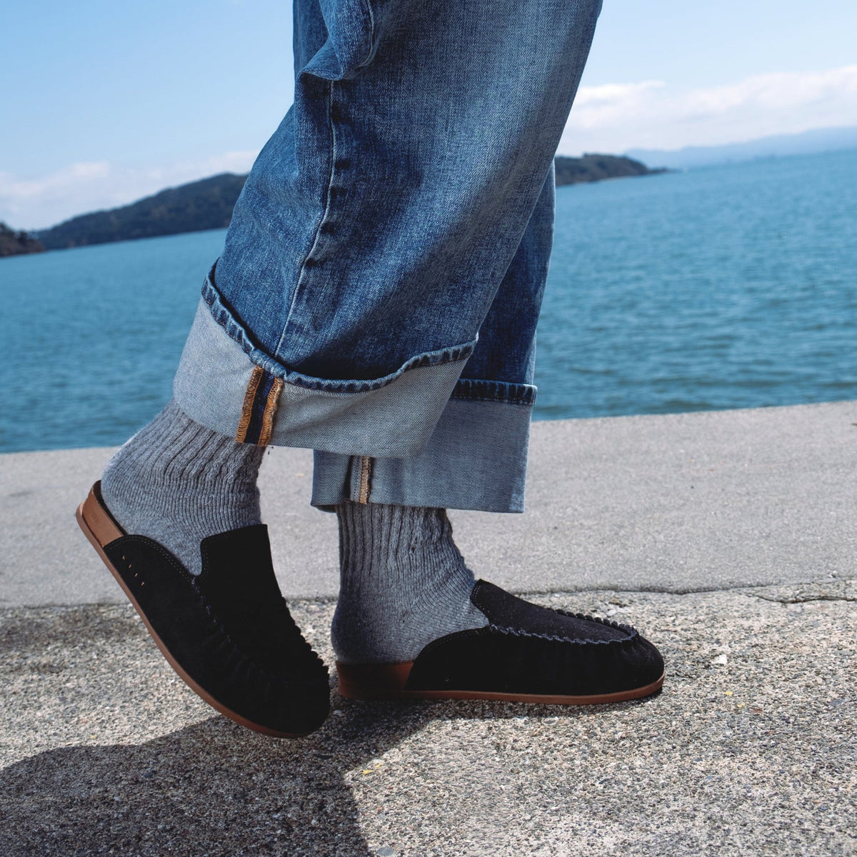 Side view of black Vista Myra clog on foot with grey socks and cuffed jeans, featuring soft-rebound cushioning and arch support.