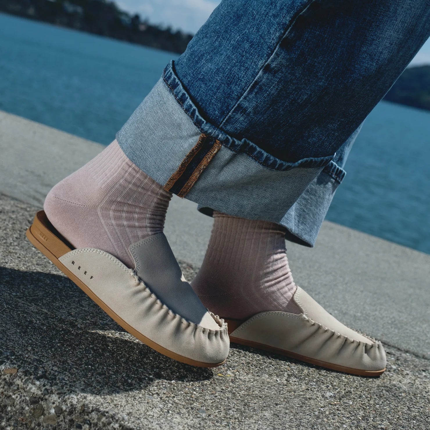 Vista Myra facing right, women's leather slip-on clog in warm sand with anatomical arch support and soft cushioning outdoors by water.