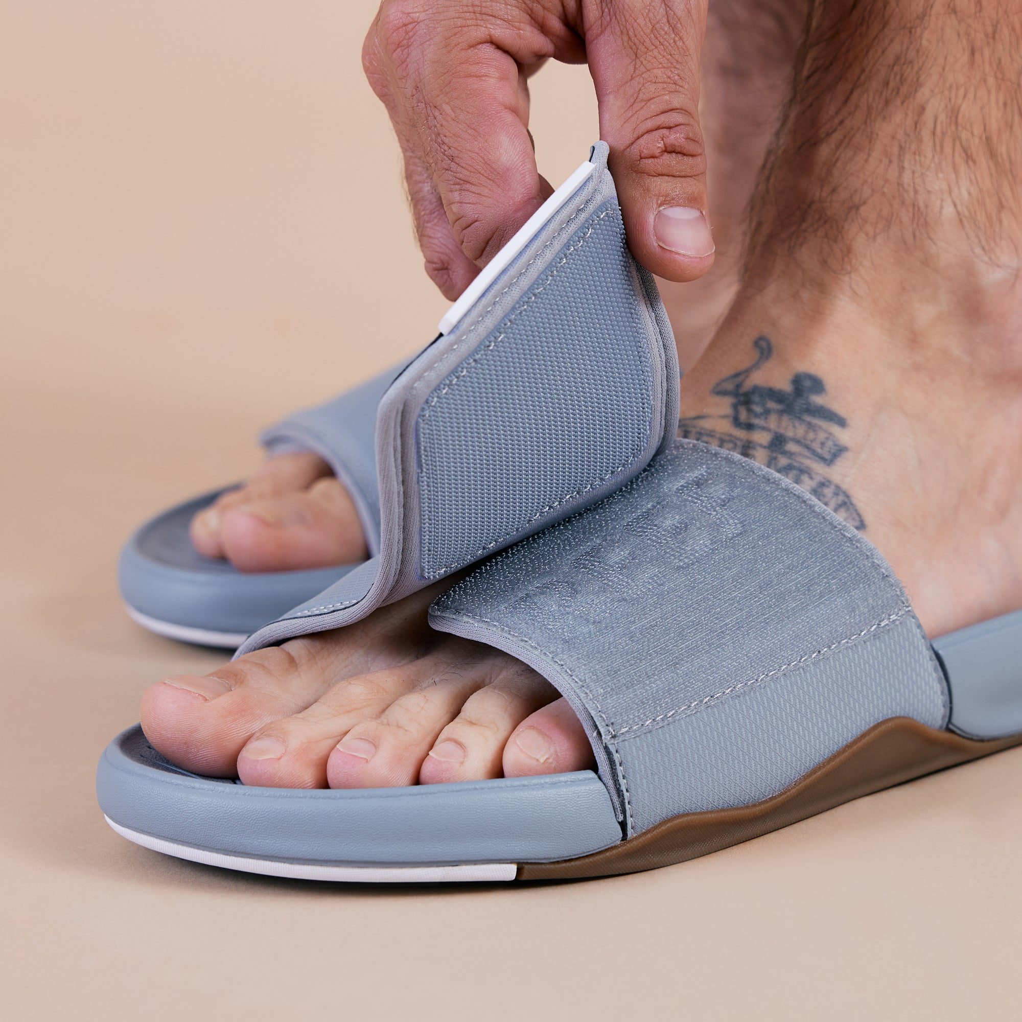Men's grey Phantom Slab slide facing left, close-up of adjustable top strap with custom arch support design