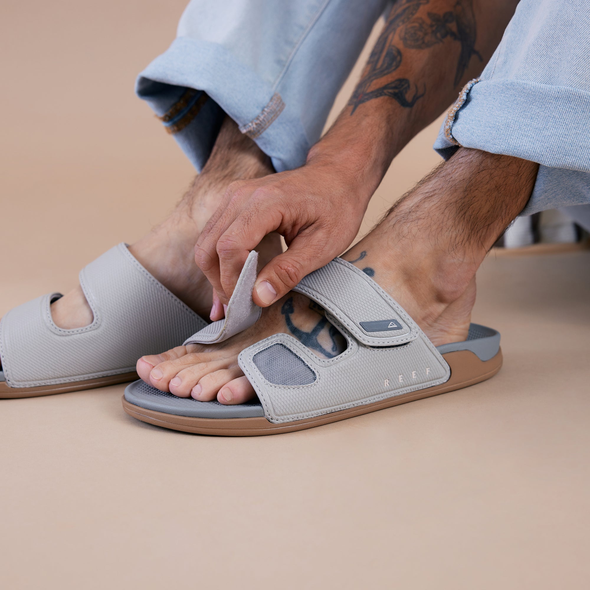 Men's Phantom Tradewind sandal facing left, close-up on upper strap being adjusted, beach-inspired comfort design.