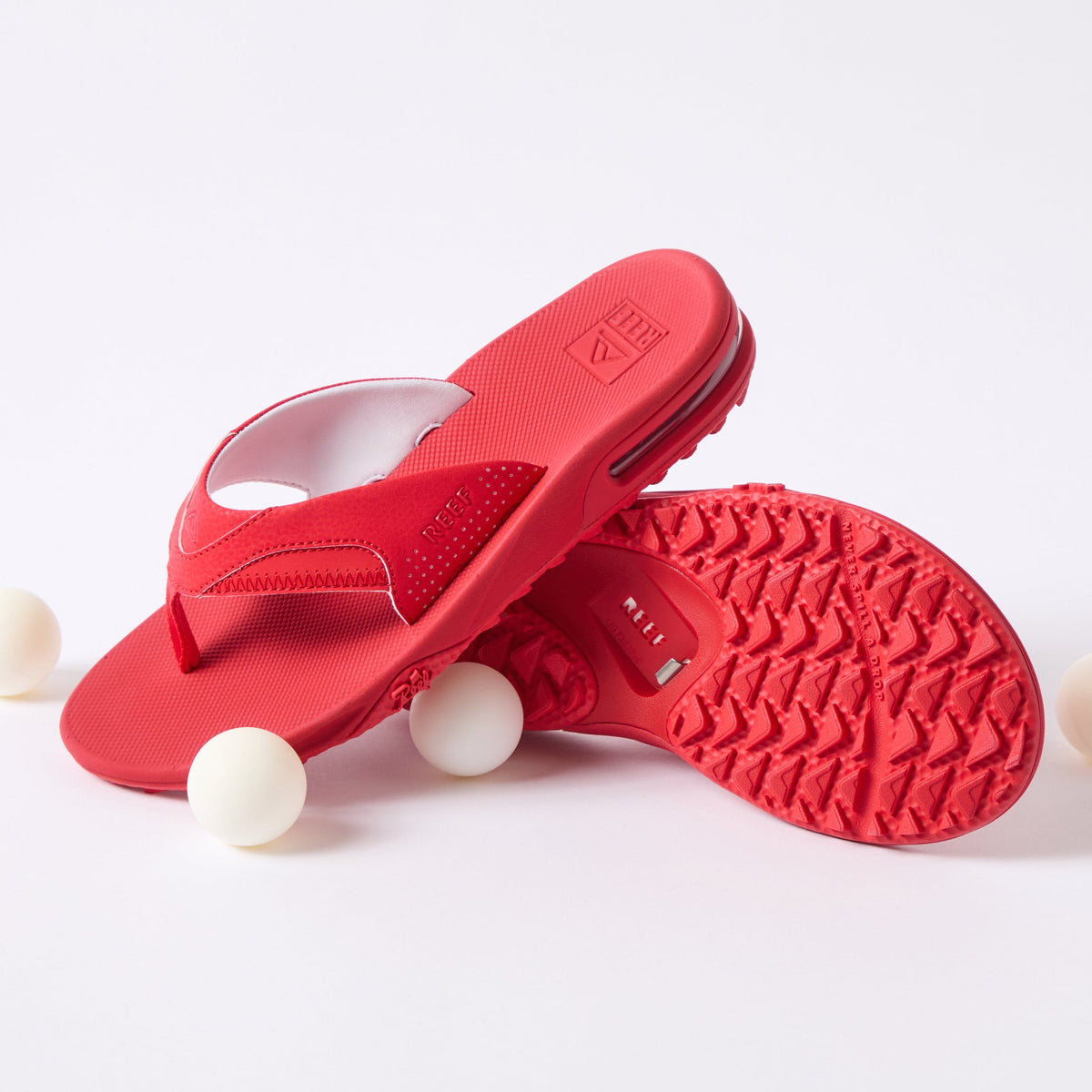 Fanning Pregame men's red flip flop facing right, close-up of sole and cushioned footbed, beach-inspired comfort design.