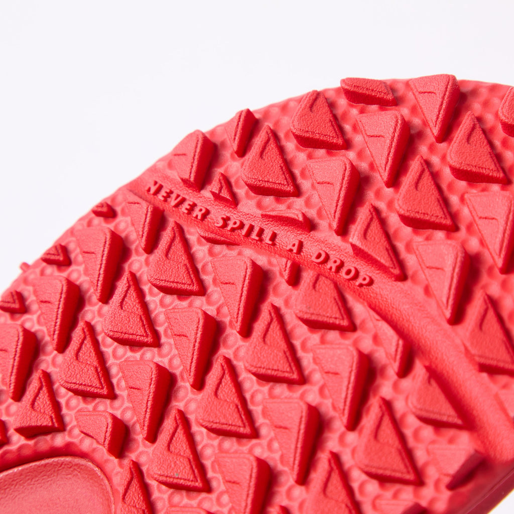 Close-up of the red Fanning Pregame sole facing upward with textured tread and "Never Spill a Drop" text visible.